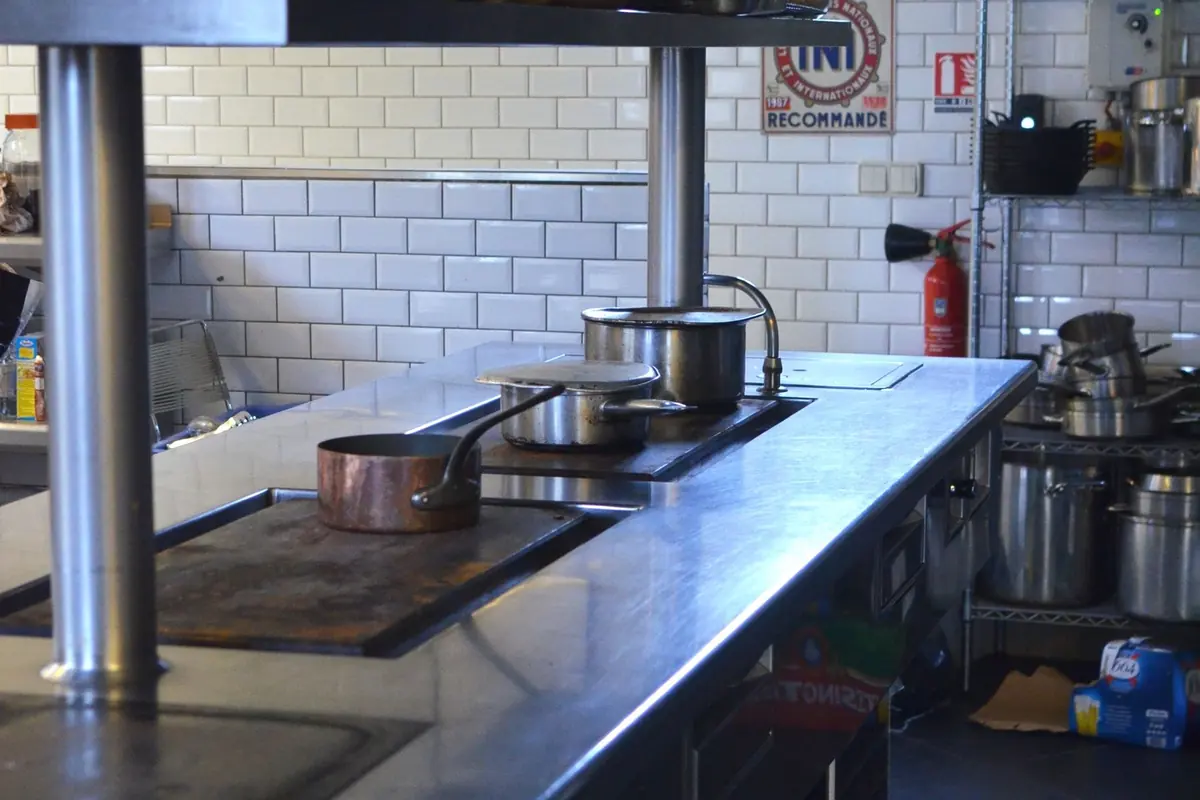 Cuisine professionnelle de restaurant en inox, sous hotte d'extraction