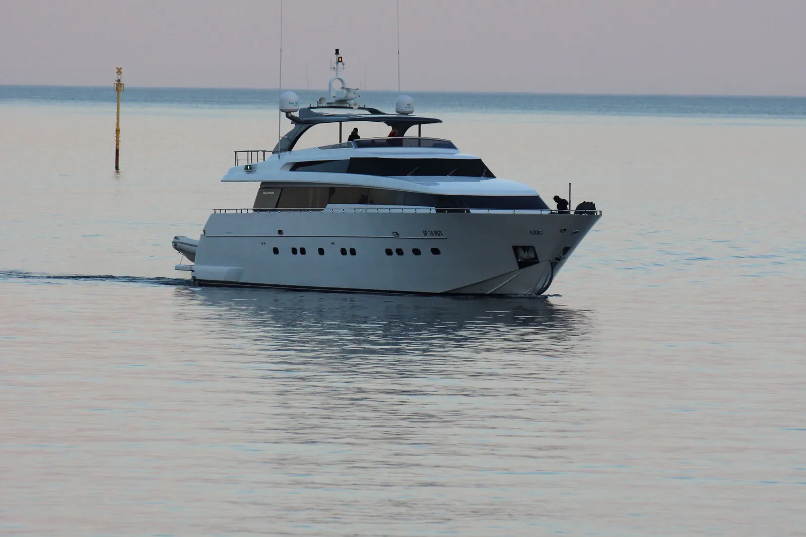 Yacht à moteur naviguant au large, mer d'huile